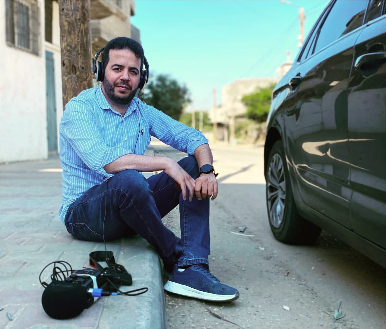 ساجي الشوا يجلس بسماعات الرأس بجانب معدات تسجيل
