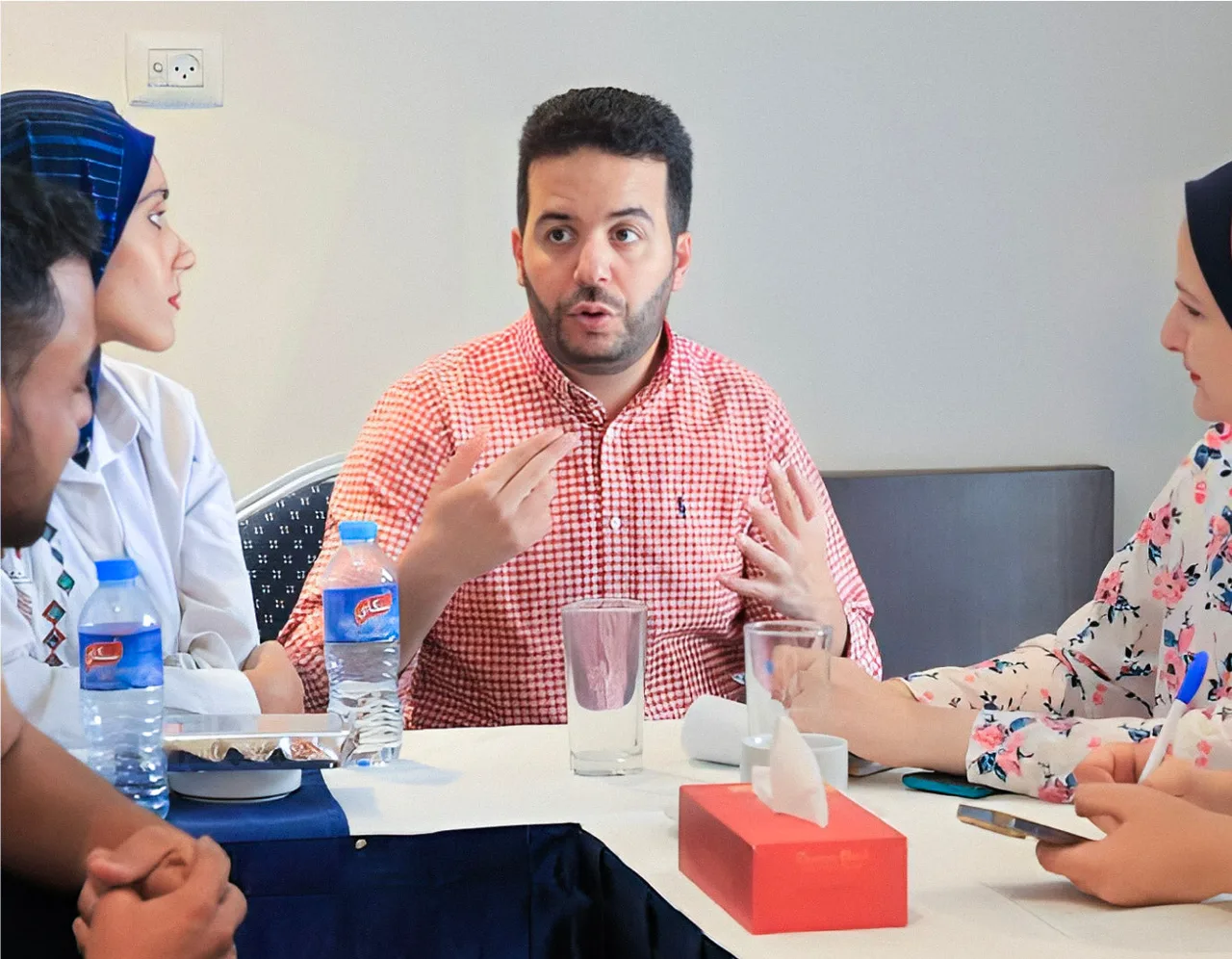 ساجي الشوا في اجتماع مع فريق حول طاولة